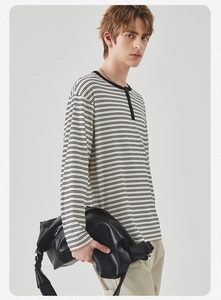 Detail van het zwart-wit gestreepte Henley-shirt met gebreide katoenen textuur