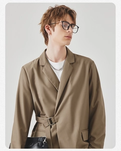 Detail view of khaki blazer with unique adjustable waist buckle and smooth fabric