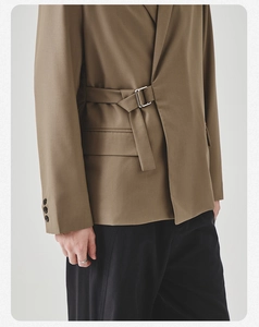 Detail of khaki casual blazer featuring metallic side adjustment buckle and woven strap