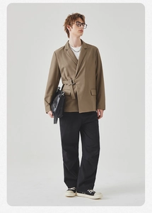 Detail view of khaki casual blazer featuring a unique metal buckle closure and minimalist design