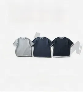 Detail van drie heren katoenen T-shirts in grijs, koningsblauw en zwart met laagjeslook