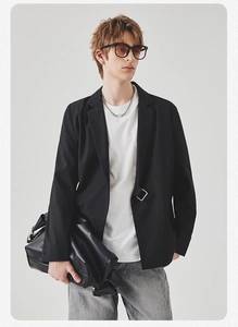 Detail of black casual blazer with square metal ring buckle and white t-shirt