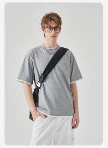 Detail van grijs gelaagd heren t-shirt met witte contrastranden en een losse pasvorm