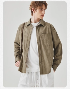 Detailed texture of olive green long sleeve shirt with front pocket and button closure