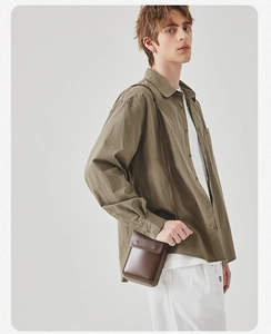 Detail of olive green long-sleeve shirt fabric texture and minimalist button design