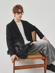 Men's casual black blazer with grey straight jeans and a stylish leather shoulder bag