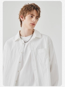 Detailed macro view of men's white long-sleeved shirt with natural cotton-linen texture