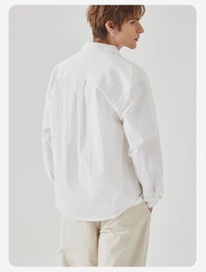 Detail of white long sleeve shirt with back pleat design and premium cotton texture