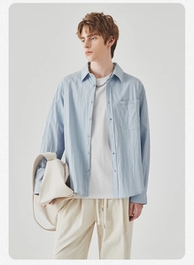 Close-up of light blue long-sleeved casual shirt with breast pocket and relaxed fit texture