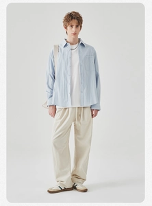 Light blue long sleeve shirt with natural texture paired with cream casual trousers