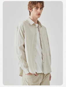 Detail view of the chest pocket and premium texture on this beige long sleeve shirt