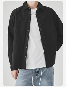 Detail of premium black long sleeve button-up shirt with chest pocket and lapel collar