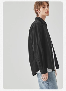 Detail of black long-sleeved casual shirt with textured fabric and buttoned cuff
