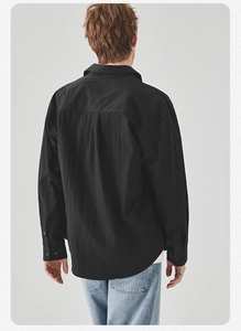Rear view of black long sleeve shirt for men with back pleat detail and premium cotton texture