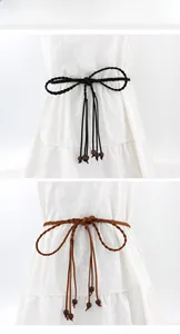 Detail view of woven waist ropes in black and brown with wooden beads on a white dress
