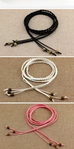 Detailed view of woven dress belts in black, white, and pink with decorative wooden beads