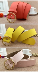 Close-up of elegant women's PU leather belts in coral, yellow, and pink with gold buckles