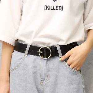 Women's black PU leather belt with round golden metal buckle on blue jeans and white tee