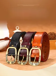 Detailed view of retro leather belts featuring embossed floral patterns and bronze buckles