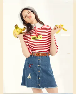 Close-up of a genuine leather belt styled with a striped tee and embroidered denim skirt