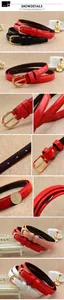 Détail de ceintures fines en cuir verni aux couleurs acidulées avec boucles dorées ondulées