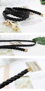 Detail of black woven PU belt featuring gold lobster clasp and square metal ends
