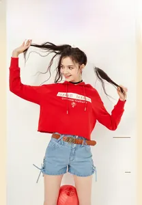 Gros plan sur le sweat à capuche court rouge avec imprimé rose et short en jean