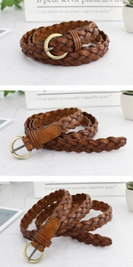 Détail d'une ceinture en cuir tressé marron avec une boucle ardillon ronde en métal bronzé