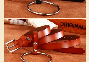 Détail macro d'une ceinture en cuir marron avec un grand anneau argenté et une boucle