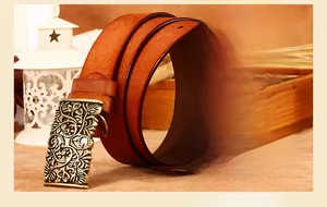 Detail of floral embossed leather belt with vintage gold hollow metal buckle and oil-edged finish