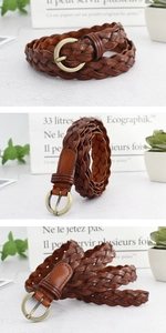 Détail de la ceinture tressée en cuir marron avec boucle ronde en métal bronze antique
