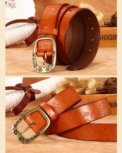Close-up of vintage butterfly embossed leather belt with bronze floral buckle and texture