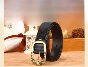 Detail of vintage black leather belt with floral patterns and an antique gold buckle
