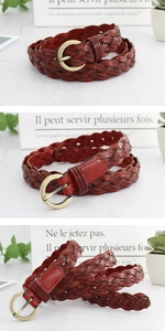 Détail de la ceinture tressée en cuir marron rouge avec boucle ronde en bronze antique