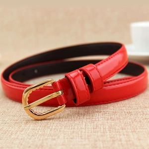 Ceinture fine en cuir verni rouge pour femme avec boucle dorée ondulée sur lin