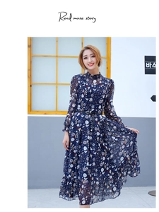 Detail of a thin woven black belt styled on a navy floral long-sleeved chiffon dress