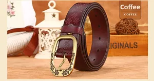 Close-up of vintage coffee brown leather belt with floral embossing and bronze buckle