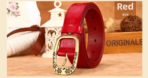 Detail of red leather belt with floral embossing and vintage gold metal buckle