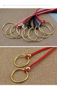 Détail de ceintures en cuir coloré avec anneaux à boucle ronde dorée sur tissu texturé