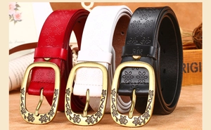 Retro women leather belt detail showing embossed floral patterns and bronze metal buckle