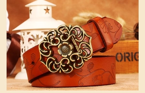 Détail de ceinture en cuir gaufré floral brun rouge avec boucle fleurie bronze vintage