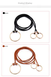 Détail de fines ceintures en cuir noir et camel avec des boucles à anneaux dorés