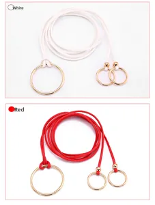 Détail de la ceinture fine tressée montrant la boucle en métal doré en blanc et rouge