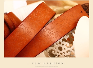 Close-up of brown cowhide leather belt featuring intricate 3D floral embossing patterns