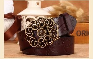 Détail de ceinture en cuir gaufré vintage avec boucle florale en laiton et décor rétro