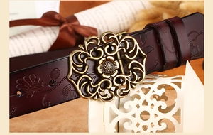 Détail de la ceinture en cuir gaufré avec une boucle dorée ajourée de style vintage