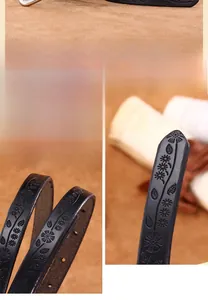 Close-up of black cowhide leather belt with embossed floral pattern and metal buckle