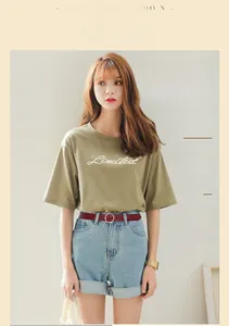 Detail of olive green crew neck t-shirt with Limited text and denim shorts outfit