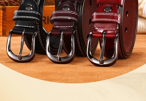 Macro detail of men's leather belts with white double stitching and alloy pin buckles