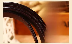 Macro shot of dark brown leather belt edges showing refined oil edge craftsmanship